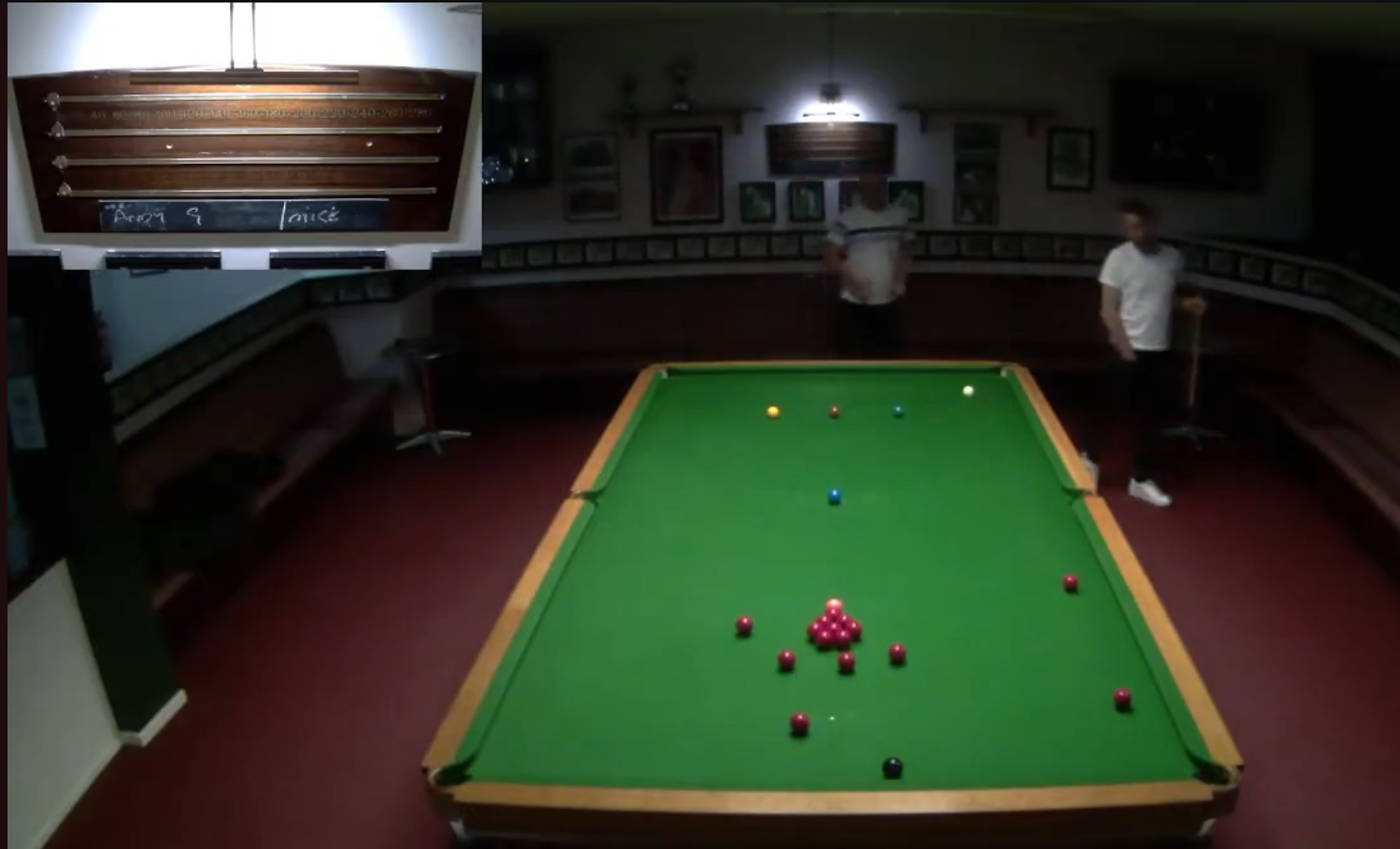 Broadcast view of the Clarence match table, with an inset camera feed of the scoreboard used to read the players' scores.